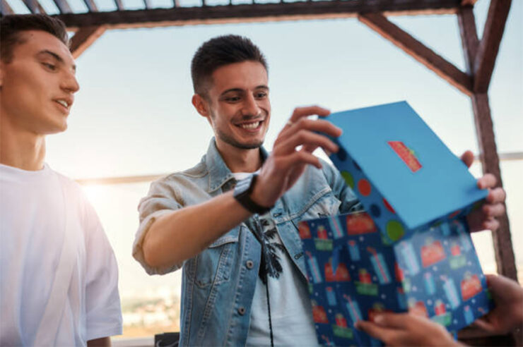 Young happy man is opening a gift 