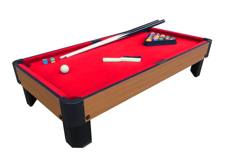 Pool Table with red top and pool ques and pool balls all on the pool table