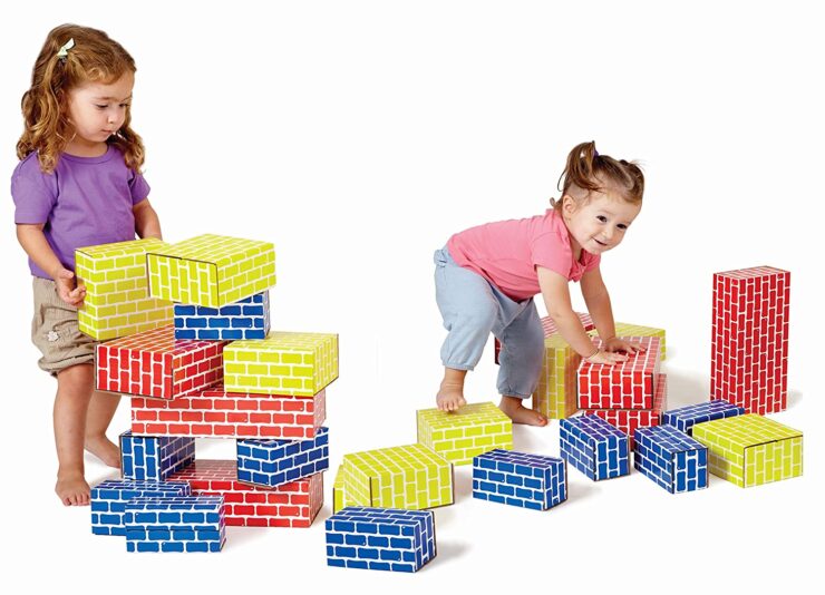 Two kids playing with Edushade corrugated Blocks in blue, yellow and red colors.