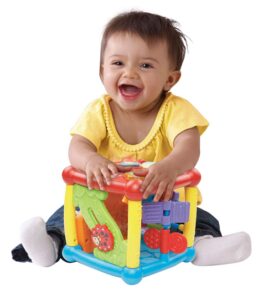 this is an image of a child playing with busy learners activity cube.
