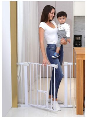 his is an image of a mom carrying her child while opening the auto close and extra tall walk thru gate with pet door. 