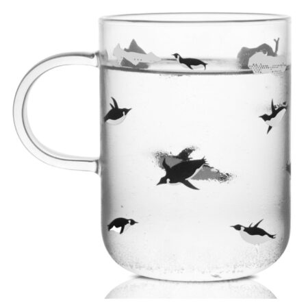 This is an image of a clear mug with penguin prints. 