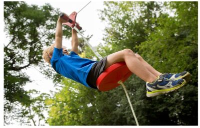 this is an image of a kid riding a zip line. 