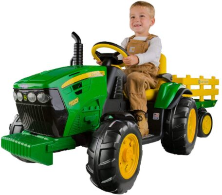 This is an image of Toddler on a Peg Perego Toddler Tractor with Trailer