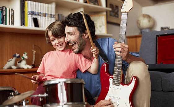 Father and son playing drums lauhging