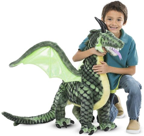 This is an image of a child holding a large stuffed dragon
