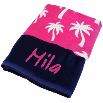 This is an image of a pink beach towel for kids with palm tree prints. 