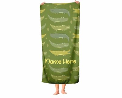 This is an image of a green personalized towel for kids with alligator prints. 