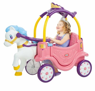 This is an image of a little girl riding a toy carriage. 