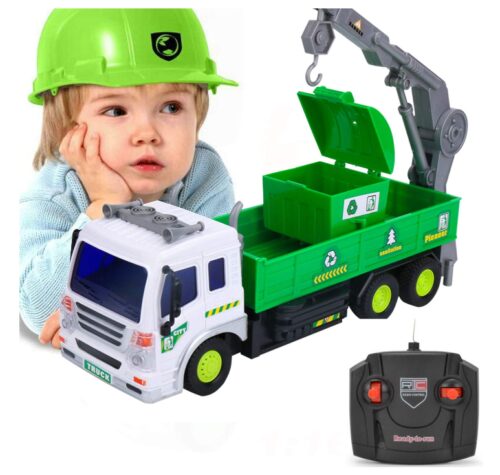 this is an image of a boy playing with a RC recycle garbage crane toy truck. 