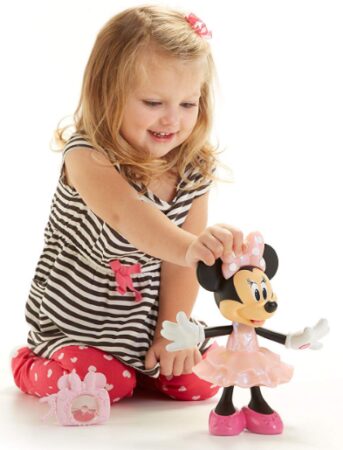 This is an image of girl playing with a Fisher-Price Disney Minnie, Rainbow Dazzle Minnie