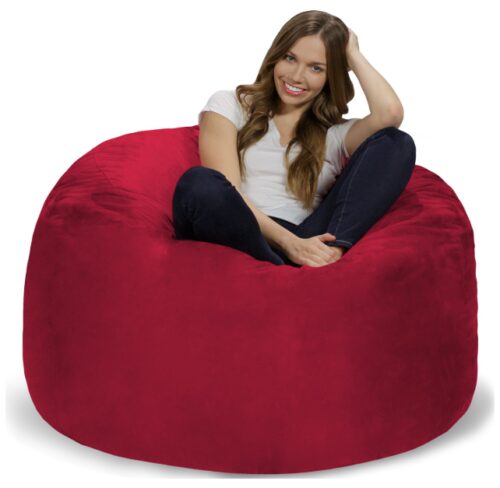this is an image of a lady sitting in a red bean bag chair. 