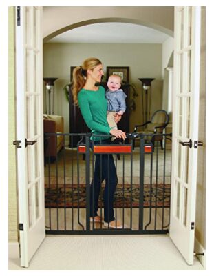 this is an image of a mom carrying her baby behind the 37-inch tall walk thru baby gate. 
