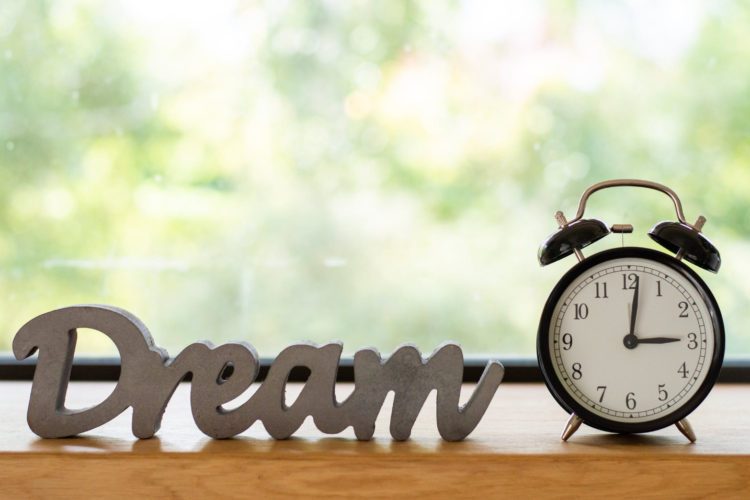 this is an image of an alarm clock with 'dream' sign beside it