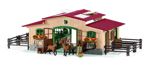 this is an image of a stable with horses and accessories for kids. 