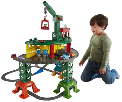 this is an image of a kids playing with a Thomas & Friends super station toy. 