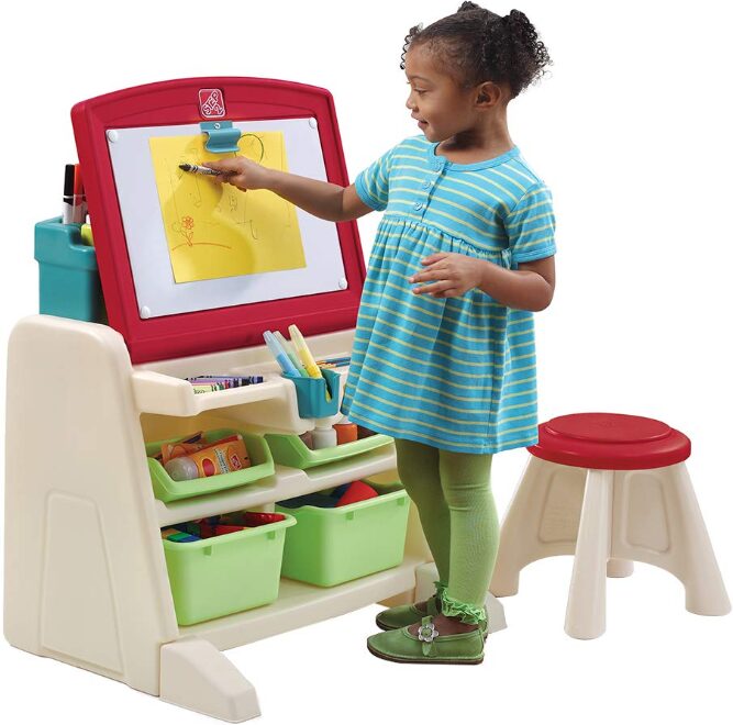 this is an image of a girl standing and drawing on a art easel table
