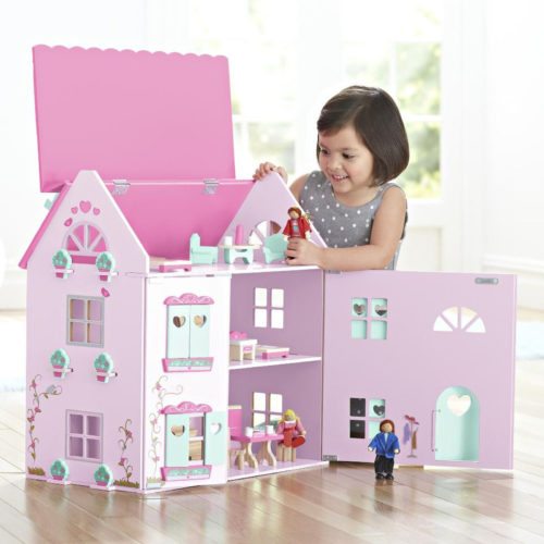 child girl is playing with a pink dollhouse