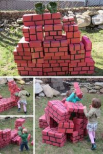 kids in the garden playing hulk wall smash-it with soft bricks