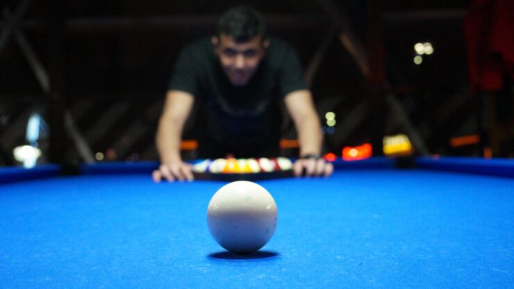 man leaning on pool table