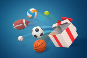 3d rendering of various sport balls jumping out of a big white gift box on blue background. Shopping and leisure. Playing sport games. Sports equipment.