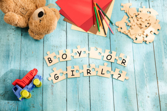 letters and pieces of puzzles on wooden background. Concept of choosing baby name, parenthood and pregnancy.