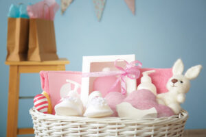 baby girls Wicker basket with baby shower gifts indoors, pink theme