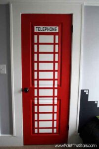 superhero entrance door in red with telephone written on the top of the door 