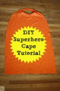 t shirt cut into a superhero costume on a wooden floor saying diy superhero cape tutorial